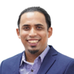 Portrait of a smiling man in a blue suit jacket and purple shirt against a white background.