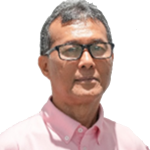 Portrait of a middle-aged man in a pink shirt and glasses, looking at the camera.