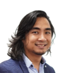 Portrait of a smiling man with shoulder-length dark hair, wearing a blue blazer and light blue shirt.