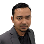 Professional headshot of a man in a dark suit and black shirt, looking at the camera against a white background.